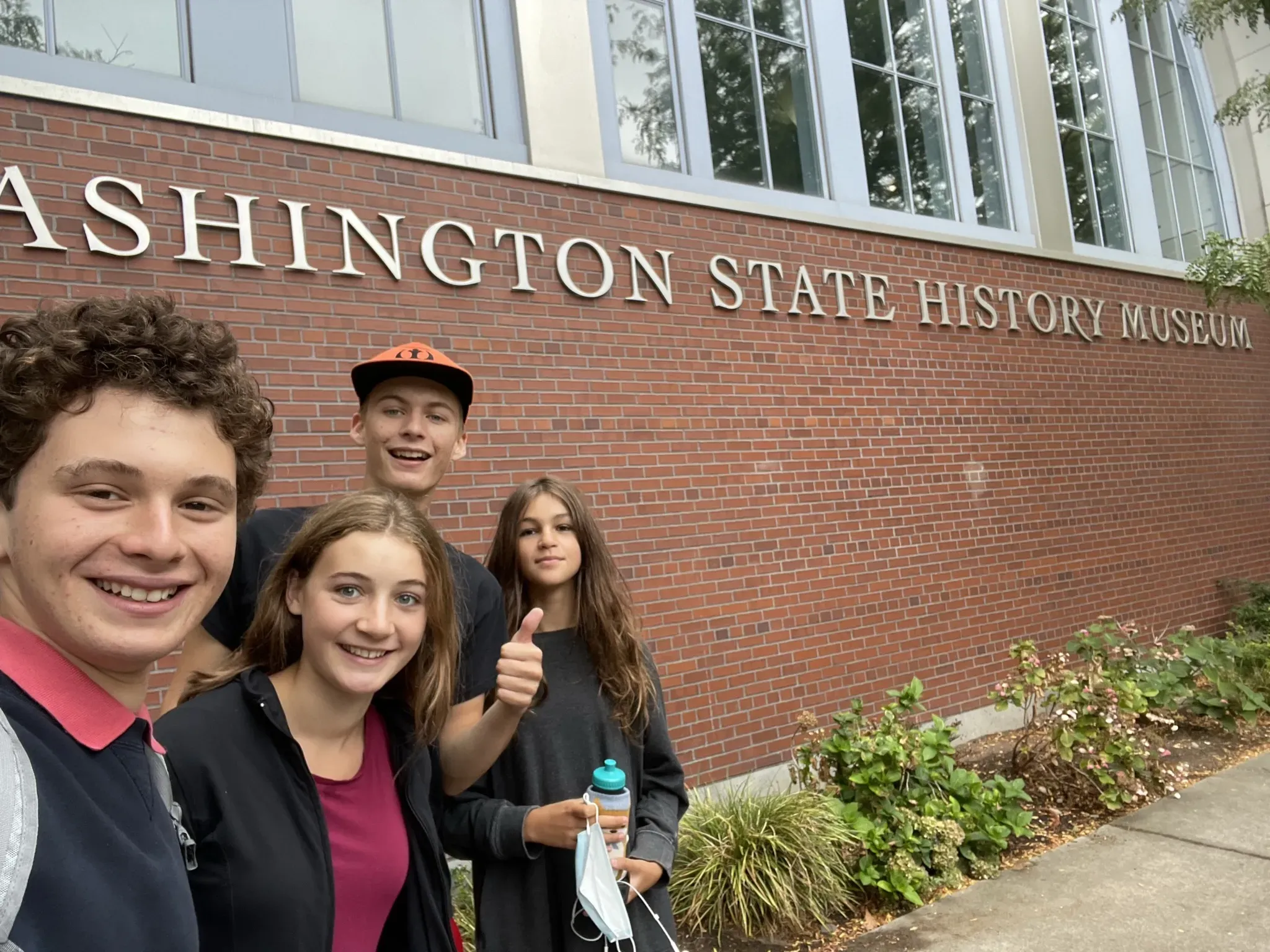 Jonah, Alice, Callum, and Anneke standing in the bottom left corner in front of the Washington State History Museum